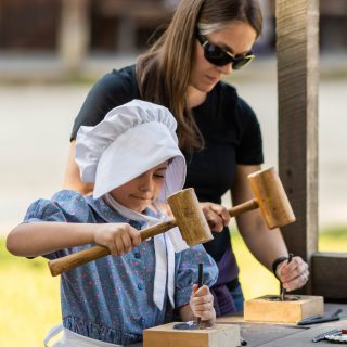 A child and adult punch a tin ornament