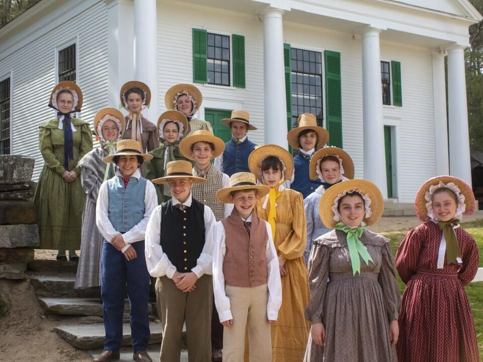 Two dozen young adults wearing 1830s attire