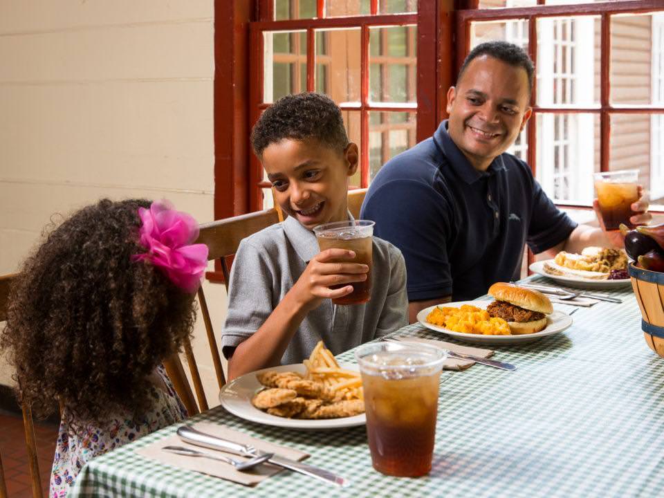 A dad and his kids eat in the Bullard Tavern