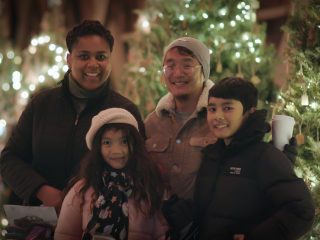 A family stands by the Christmas Wish Bridge