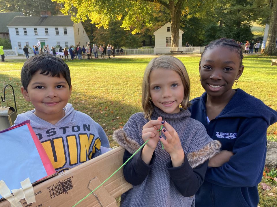 three elementary school children on the Village common