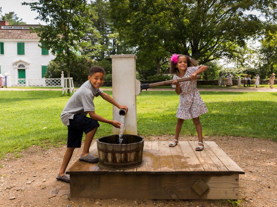 Two kids trying out the Water Pump