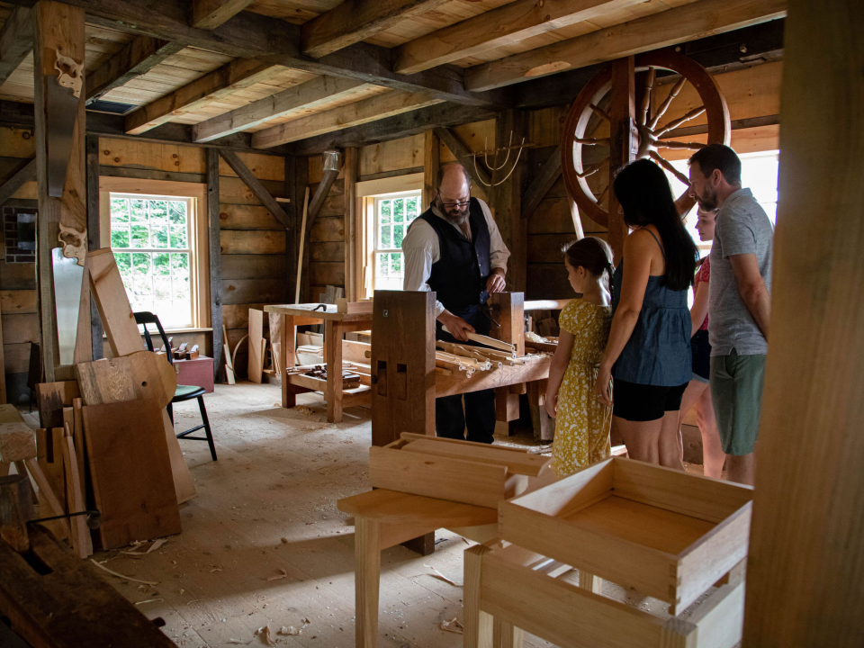 A family visits the Cabinetmaking Shop